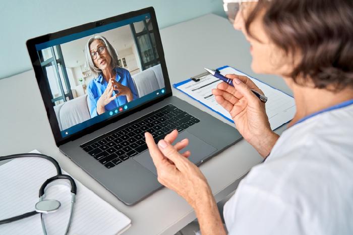 Patient consulting doctor through Telehealth Services at First Care Family Clinic using online video call.