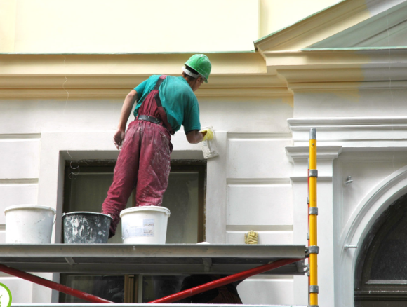 a man painting exterior of a commercial building